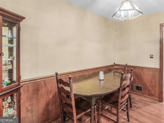 2643 Rocky Creek Rd, Hampton, GA 30228 - dining area with a wainscoted wall, wood walls, light wood-style floors, and visible vents