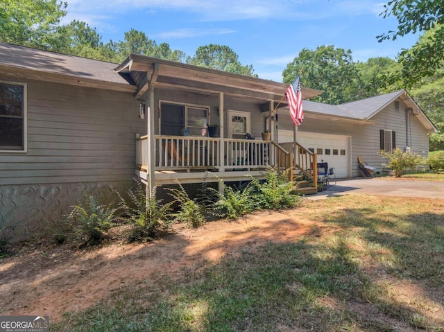 ranch-style house with concrete driveway, an attached garage, covered porch, and a front yard