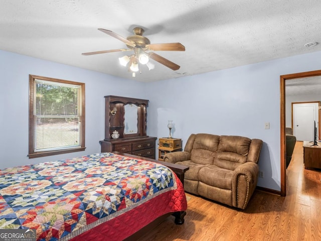 2643 Rocky Creek Rd, Hampton, GA 30228 - bedroom with baseboards, a textured ceiling, wood finished floors, and a ceiling fan