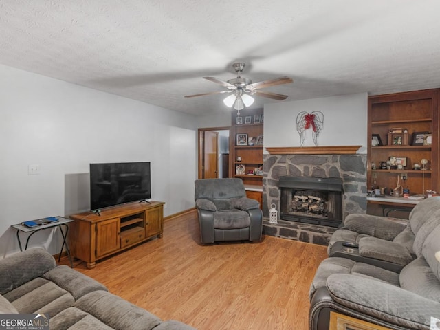 2643 Rocky Creek Rd, Hampton, GA 30228 - living room featuring light wood-style floors, a stone fireplace, and a textured ceiling