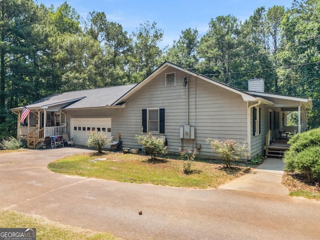 2643 Rocky Creek Rd, Hampton, GA 30228 - view of front facade featuring aphalt driveway, covered porch, a chimney, and a garage