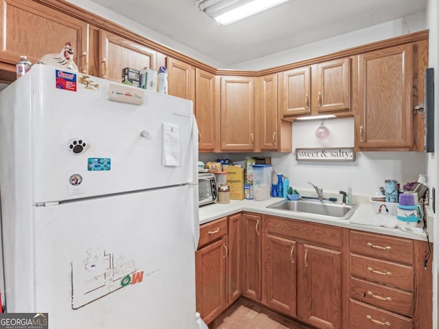 2643 Rocky Creek Rd, Hampton, GA 30228 - kitchen with a sink, stainless steel microwave, freestanding refrigerator, brown cabinetry, and light countertops