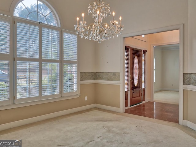 entryway featuring a wealth of natural light, a notable chandelier, and baseboards