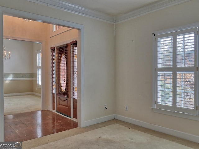 entrance foyer featuring baseboards, a notable chandelier, and ornamental molding