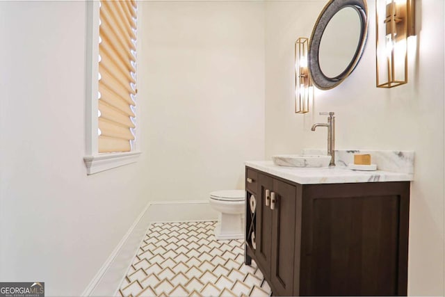 bathroom featuring tile patterned flooring, toilet, vanity, and baseboards