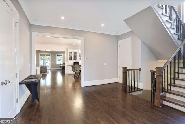 interior space featuring stairs, wood finished floors, baseboards, and ornamental molding