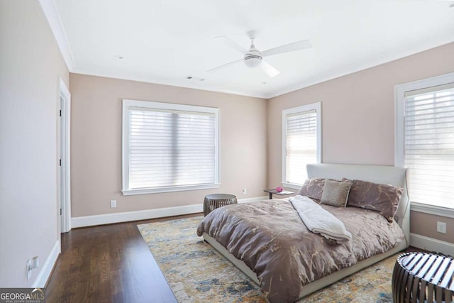 bedroom with a ceiling fan, wood finished floors, baseboards, visible vents, and crown molding