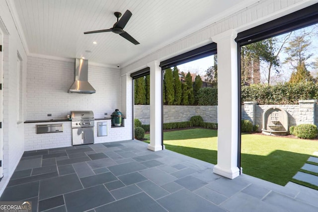 view of patio / terrace with exterior kitchen, a ceiling fan, fence, and a grill