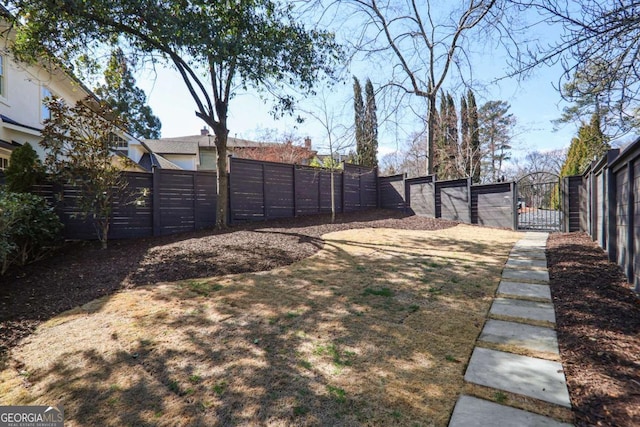 view of yard featuring fence and a gate