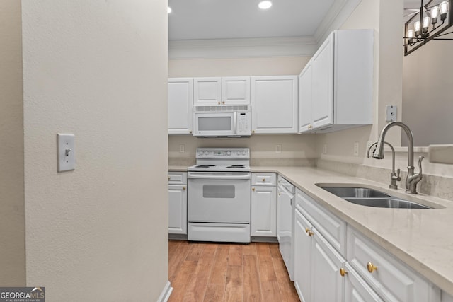 kitchen featuring a sink, white appliances, white cabinets, and crown molding