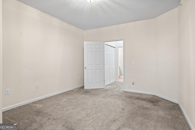 unfurnished room with baseboards and carpet floors