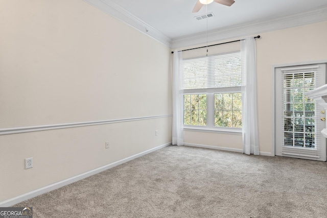 empty room with visible vents, crown molding, baseboards, carpet, and a ceiling fan