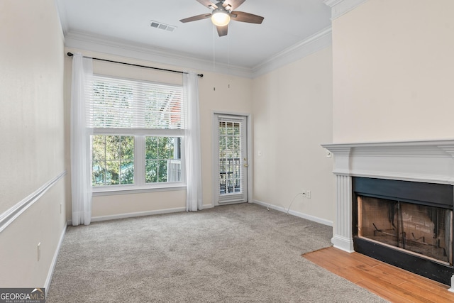 unfurnished living room featuring visible vents, carpet flooring, baseboards, and ornamental molding