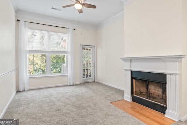 unfurnished living room featuring visible vents, crown molding, baseboards, carpet, and a fireplace with flush hearth