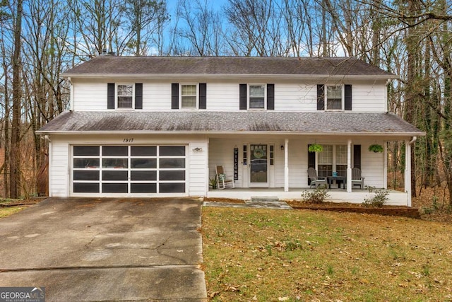 view of front of home featuring a front yard, driveway, roof with shingles, a porch, and a garage