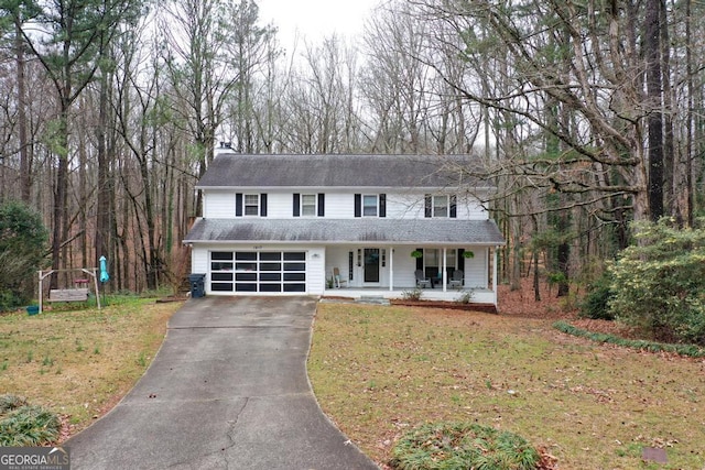 view of front of house with driveway, a front lawn, a porch, a garage, and a chimney