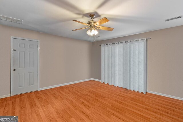 spare room featuring light wood-style flooring, baseboards, and visible vents