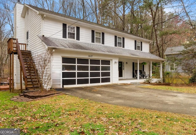 view of front of property featuring stairway, driveway, covered porch, a chimney, and a garage