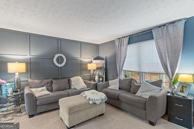 carpeted living room with a decorative wall and a textured ceiling