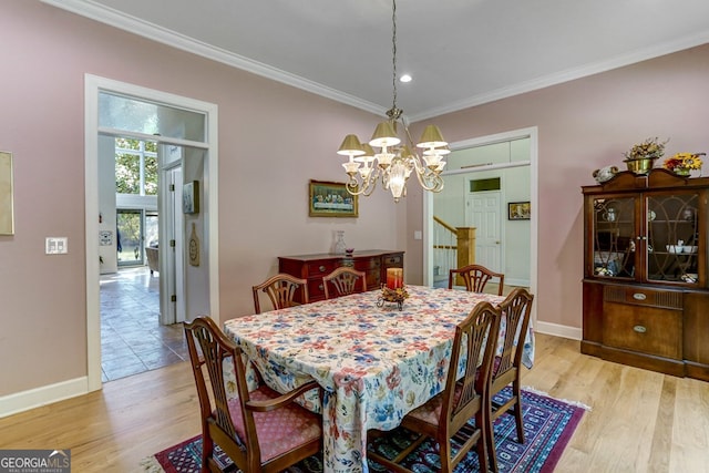 dining room featuring crown molding, light wood-style floors, and baseboards