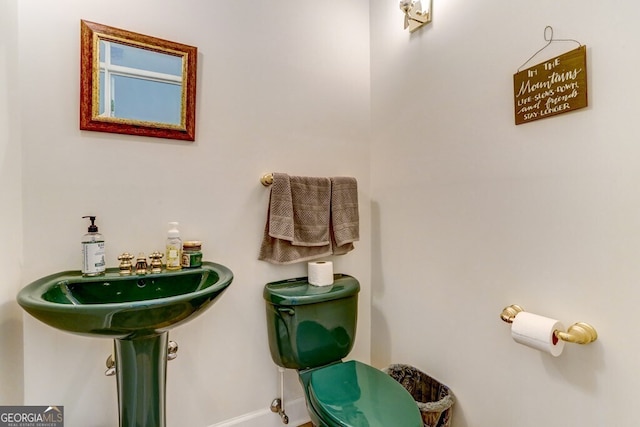 half bathroom with a sink and baseboards