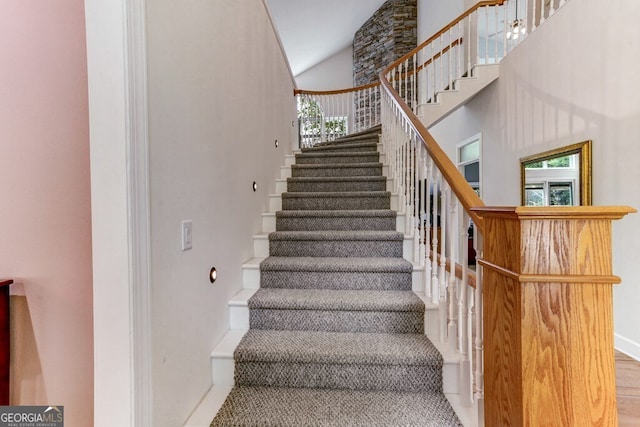 stairs featuring baseboards and a towering ceiling