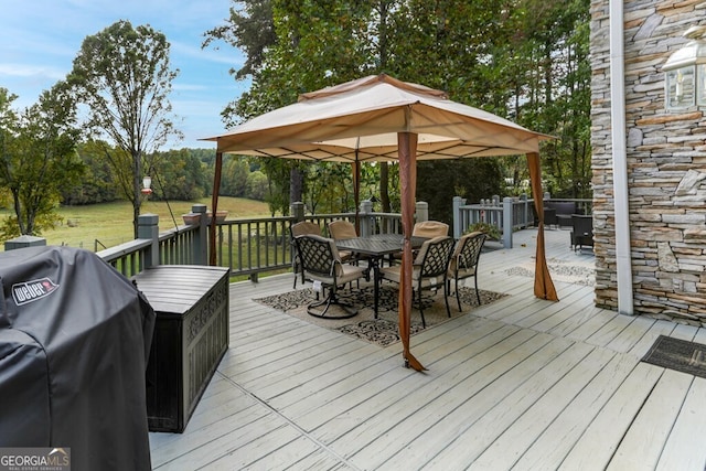 wooden terrace featuring grilling area and outdoor dining area