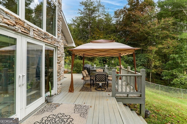 deck featuring a gazebo, outdoor dining space, and fence