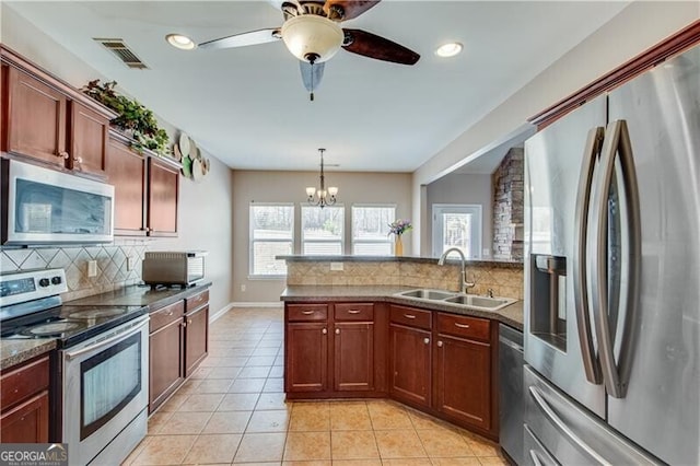 kitchen with visible vents, light tile patterned floors, appliances with stainless steel finishes, a peninsula, and a sink