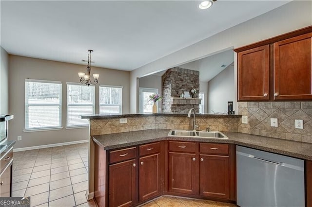 kitchen with a sink, backsplash, dark countertops, a peninsula, and dishwasher