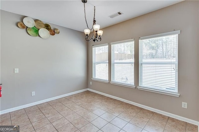 empty room featuring visible vents, baseboards, a chandelier, and light tile patterned flooring