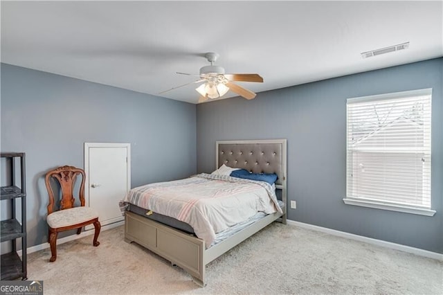 bedroom featuring light carpet, visible vents, a ceiling fan, and baseboards