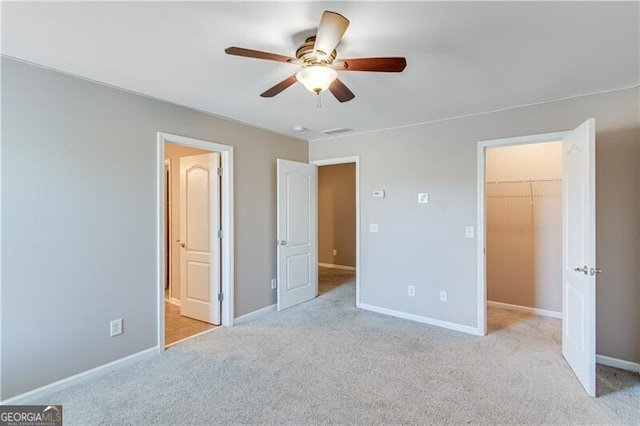 unfurnished bedroom with a spacious closet, baseboards, and carpet floors