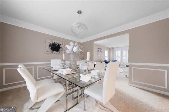 dining area featuring carpet flooring, a wainscoted wall, and ornamental molding