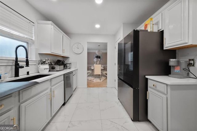 kitchen featuring a sink, light countertops, white cabinets, appliances with stainless steel finishes, and marble finish floor