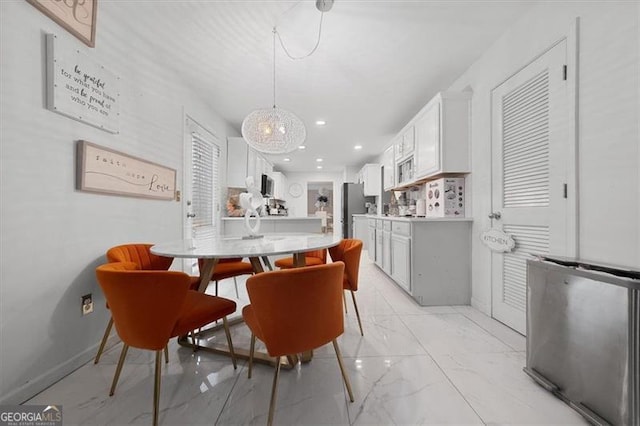 kitchen featuring light countertops, recessed lighting, white cabinets, freestanding refrigerator, and marble finish floor