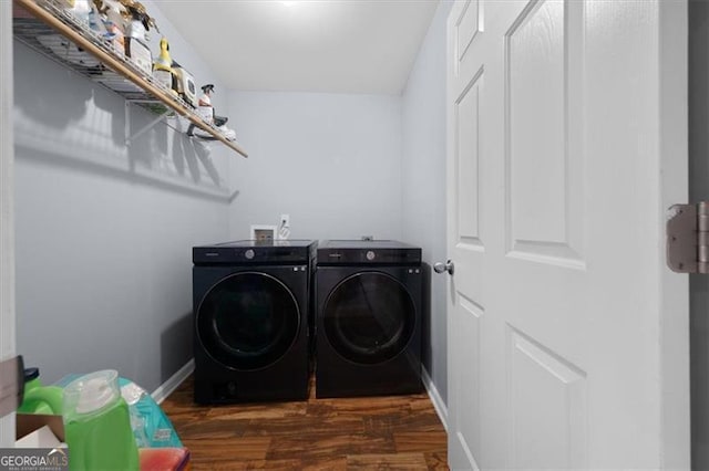 clothes washing area with baseboards, wood finished floors, laundry area, and washer and clothes dryer