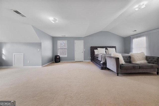 bedroom featuring visible vents, lofted ceiling, multiple windows, and light carpet