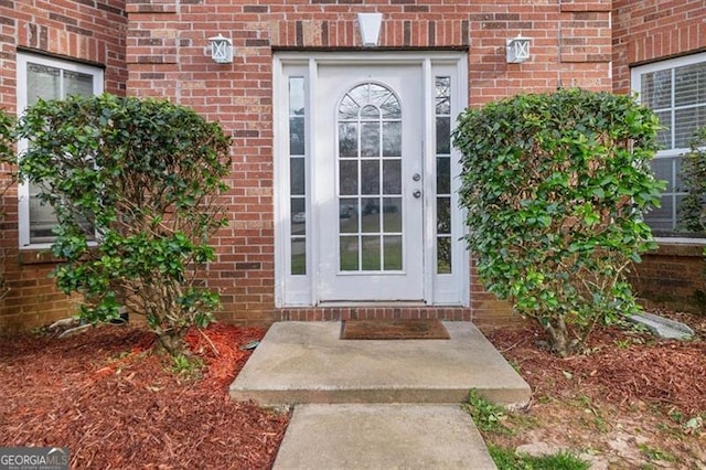 property entrance featuring brick siding