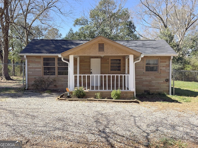 view of front of property with fence, covered porch, and stone siding