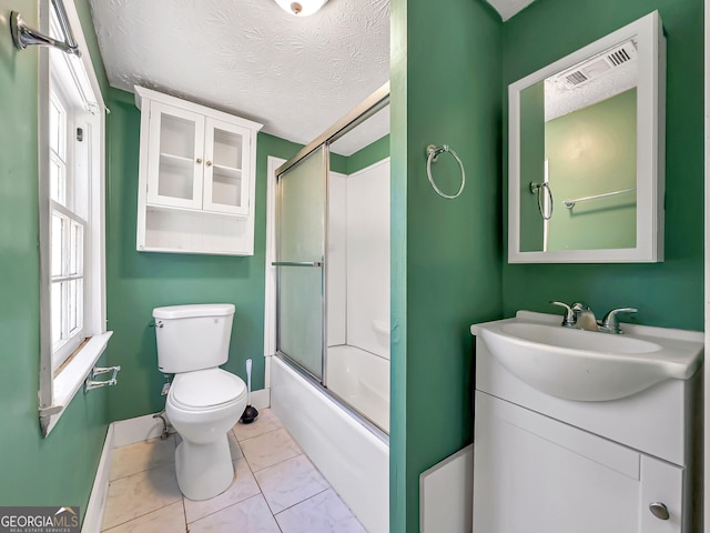 bathroom featuring toilet, a textured ceiling, vanity, and bath / shower combo with glass door