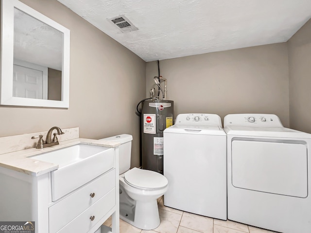 half bath with vanity, visible vents, water heater, washer and dryer, and toilet