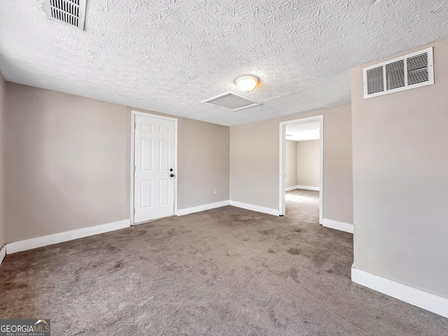 interior space featuring visible vents, baseboards, a textured ceiling, and attic access