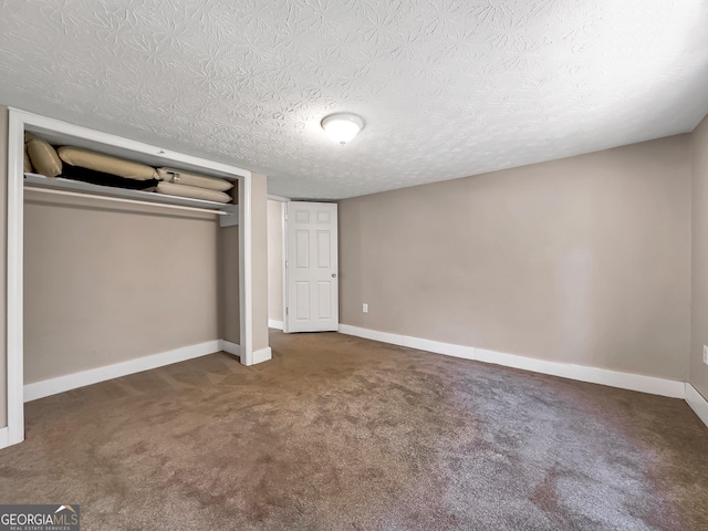 unfurnished bedroom featuring carpet, baseboards, a closet, and a textured ceiling