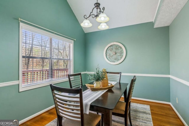 4125 Gables Pl, Buford, GA 30519 - dining area with a chandelier, wood finished floors, and vaulted ceiling
