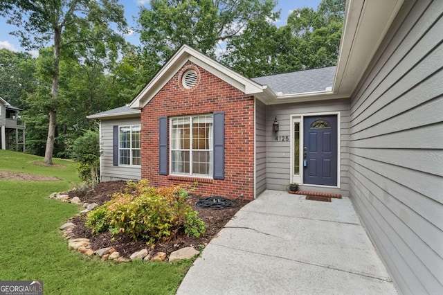 4125 Gables Pl, Buford, GA 30519 - property entrance with brick siding, a yard, and roof with shingles