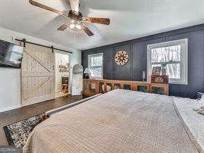 bedroom with a barn door and ceiling fan