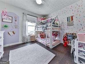 bedroom featuring wallpapered walls, a ceiling fan, and baseboards