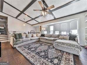 living room with beam ceiling, coffered ceiling, and ceiling fan