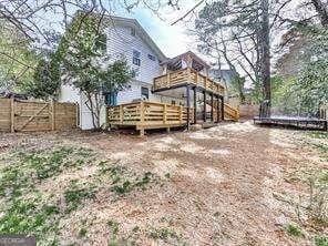 back of property featuring a gate, a wooden deck, and fence